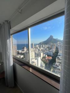 a room with a large window with a view of the city at Apartamento com Vista Imperdível in Rio de Janeiro