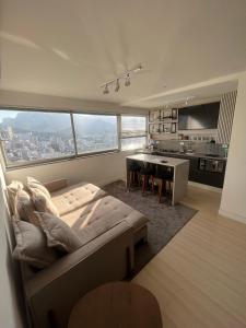 a bedroom with a bed and a table and a kitchen at Apartamento com Vista Imperdível in Rio de Janeiro