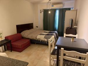 um quarto com uma cama, uma mesa e uma cadeira em Mitre 228 em Rosário