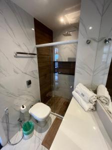 a white bathroom with a toilet and a shower at Apartamento com Vista Imperdível in Rio de Janeiro