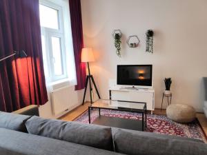 - un salon avec un canapé et une télévision dans l'établissement Humboldt Feel Good Apartments, à Vienne