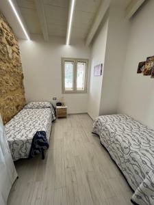 - une chambre avec 2 lits et du parquet dans l'établissement Villa Sovareto, à Sciacca