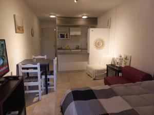 uma sala de estar com um sofá, uma mesa e uma cozinha em Mitre 228 em Rosário