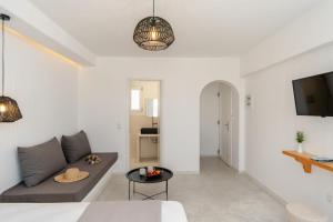 a white living room with a couch and a tv at Celestial Seaview Apartments-Portara in Naxos Chora