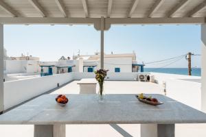a table with a vase of fruit on a balcony at Celestial Seaview Apartments-Portara in Naxos Chora