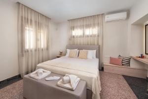a bedroom with a large bed with two towels on it at My Pixida Apartments in Rhodes Town