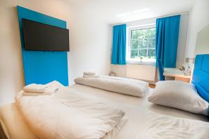 a bedroom with two beds and a flat screen tv at besttime Hotel Boppard in Boppard
