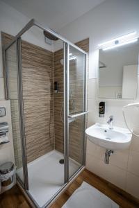 ein Bad mit einer Dusche und einem Waschbecken in der Unterkunft besttime Hotel Boppard in Boppard