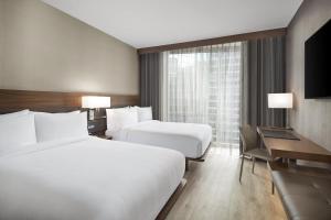 een hotelkamer met 2 bedden en een bureau bij AC Hotel by Marriott Lansing University Area in Lansing