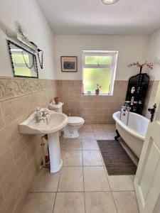 y baño con lavabo, bañera y aseo. en LOCH CONNELL LODGE rooms 1 2 3 4 5 en Letterkenny