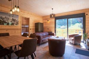 a living room with a couch and a table at Chalet le Lys Martagon in Saint-Pierre-dʼEntremont