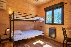 a bedroom with bunk beds in a log cabin at Chalet le Lys Martagon in Saint-Pierre-dʼEntremont