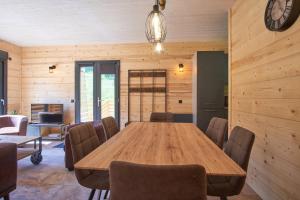 uma sala de jantar com uma mesa de madeira e cadeiras em Chalet le Lys Martagon em Saint-Pierre-dʼEntremont