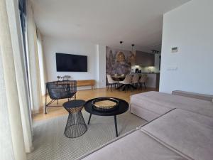 a living room with a couch and a table at Casa Buena Vista con piscina y ascensor in Cullera