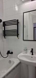 a white bathroom with a sink and a mirror at SOPRANO APARTMENT KRAKIVSKA 34 in Lviv +22 photos