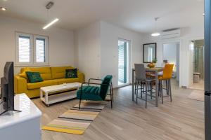 een woonkamer met een gele bank en een tafel bij Apartments Jurica in Trogir