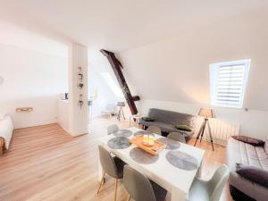 - un salon avec une table et des chaises blanches dans l'établissement Vue quai de Saône Aurore, à Chalon-sur-Saône