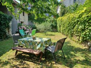 a table and chairs in a yard with a table and chairs at Les Glycines in Le Vigan