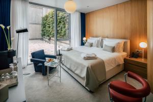 a bedroom with a large bed and a red chair at Met Boutique Hotel in Zagreb