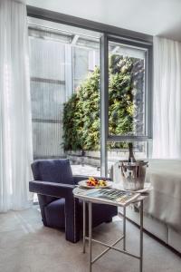 ein Wohnzimmer mit einem Tisch, einem Stuhl und einem Fenster in der Unterkunft Met Boutique Hotel in Zagreb