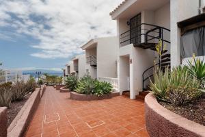 a walkway in front of a building with plants at Torviscas Alta Vista in Adeje