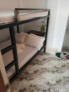 a bunk bed with white sheets and pillows on it at Casita Lodge Kubo in San Juan
