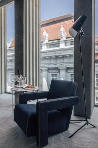 una silla y una lámpara en una habitación con un edificio en Met Boutique Hotel, en Zagreb