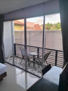 a room with a balcony with a table and chairs at La Piccola Kata in Kata Beach