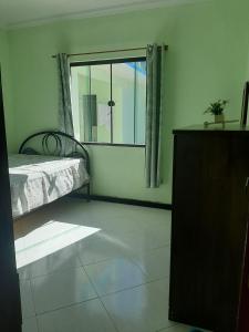 a bedroom with a bed and a large window at Linda casa pertinho da Lagoa in Iguaba Grande