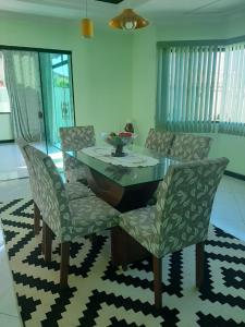 a dining room with a glass table and chairs at Linda casa pertinho da Lagoa in Iguaba Grande