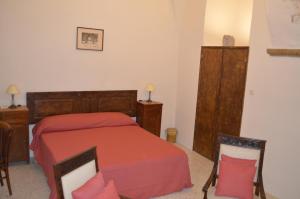 Schlafzimmer mit einem Bett mit roter Bettwäsche und Holzmöbeln in der Unterkunft Domus Lina in Ravello