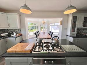 a kitchen with a stove top and a table at LOCH CONNELL LODGE Annagry rooms 1 2 3 4 5 in Letterkenny