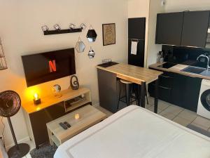 a room with a kitchen with a table and a bar at Studio Pessac Centre Tram & Parking in Pessac