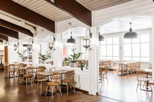 - une salle à manger avec des tables, des chaises et des fenêtres dans l'établissement Kraja, à Arjeplog
