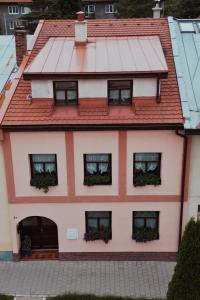 a house with a red roof and windows at Apartmány Starý trh in Kežmarok