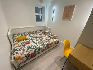 - une petite chambre avec un lit et une chaise jaune dans l'établissement Walter Road Holiday Home Swansea - 4 bedrooms, à Swansea