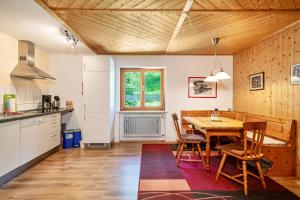 een keuken en eetkamer met een houten tafel en stoelen bij Balzerberg in Weiler-Simmerberg