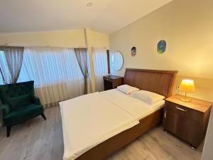 a bedroom with a bed and a green chair at NAVAL HOTEL YALOVA in Yalova