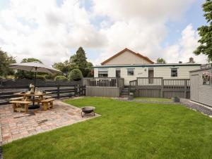 a backyard with a picnic table and an umbrella at Tyn Clwt in Caernarfon