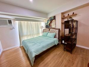 a bedroom with a bed and a book shelf at Feels Like Home Condos Abreeza Place Tower 1 & 2 in Davao City