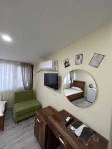 ein Wohnzimmer mit einem Spiegel und einem grünen Sofa in der Unterkunft NAVAL HOTEL YALOVA in Yalova