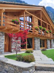 a house with a balcony with flowers on it at Firnelicht in Gressoney-Saint-Jean +24 photos