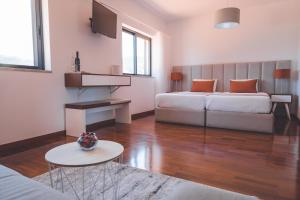 アルママールにあるQuinta da Portela Douroのベッドルーム1室(ベッド1台、ソファ、テーブル付)