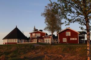 un groupe de maisons sur une colline plantée d'arbres dans l'établissement Kraja, à Arjeplog