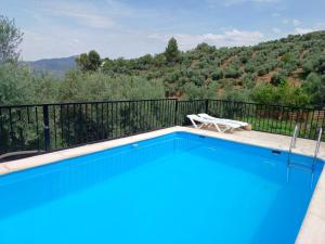 una piscina azul con una silla en el balcón en Cortijo las lagunillas en La Puerta de Segura