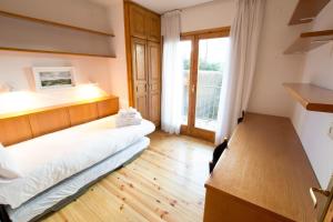 アルプにあるCasa amb jardí Alpのベッドと窓が備わる小さな客室です。