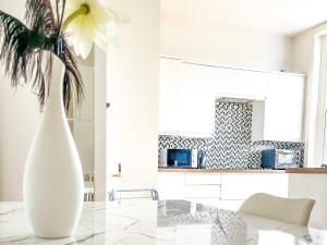 un soggiorno bianco con un vaso bianco e una pianta di Beautiful 2-Bed Apartment in London a Londra