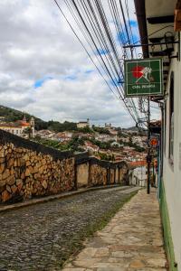 una strada con un cartello sul lato di un edificio di - Casa Pitanga - Acomodação lindíssima pertinho da Igreja do Rosário a Ouro Preto