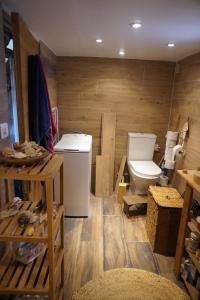 a bathroom with a toilet in a room with wooden walls at Loft cosy et lumineux à Paris,Les Lilas dans un quartier convivial proche du métro 11 "Mairie des Lilas" et du tram T3b "porte des Lilas" in Bagnolet +18 photos
