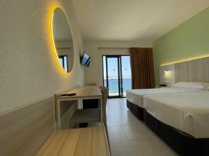 una camera d'albergo con letto e specchio di Hotel Marconi a Benidorm